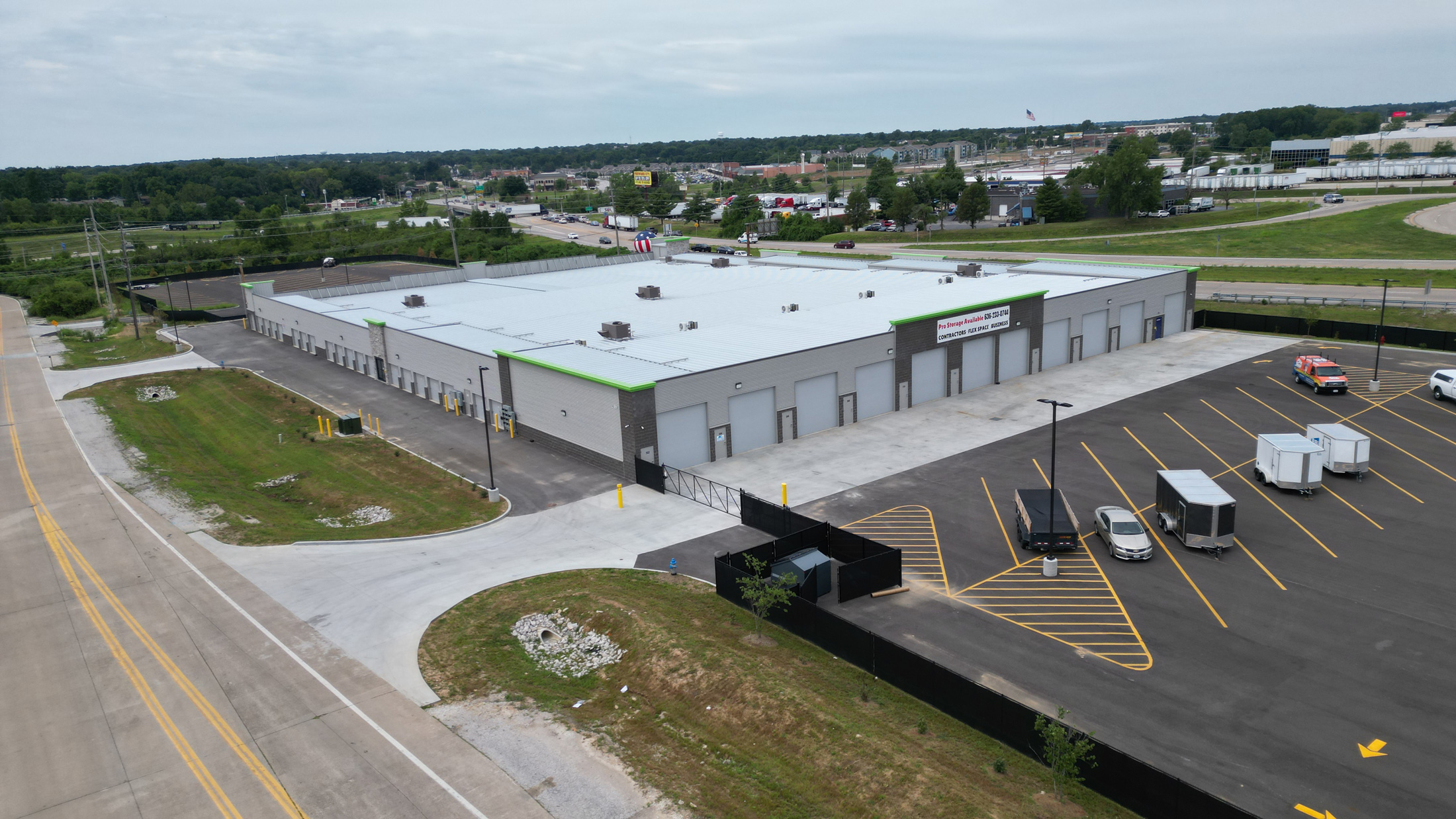 DJI_0220-web Aerial view of a large industrial warehouse with multiple loading bays and surrounding parking lot.